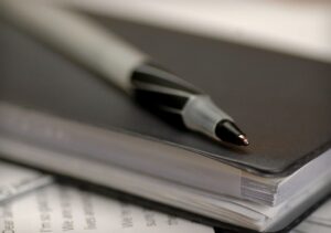 photo of a pen on top of a checkbook